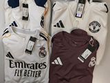 Trois maillots de football sont posés sur une table, encore étiquetés.