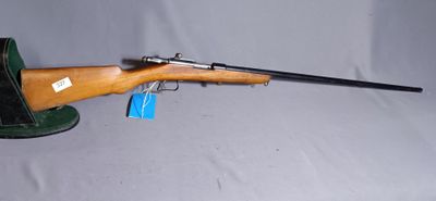 the rifle is sitting on top of the hat on the table