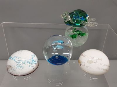 three glass balls on display in a clear display case