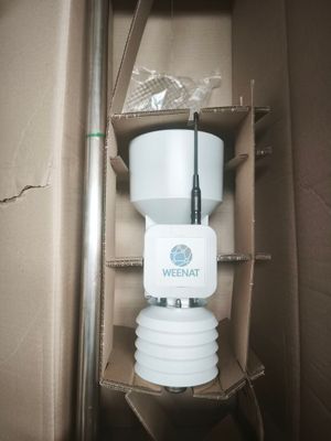 a white toilet in a box with a radio on it