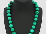 un collier de perles vertes sur un mannequin noir
