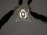 a close up of a necklace with a picture of a person on it