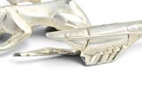 a silver figurine of a dog on a plane