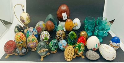de nombreux œufs et vases de différentes couleurs posés sur une table