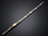 a close up of a black and gold bracelet on a black background