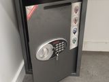 a safe box with a key on it in the corner of a room