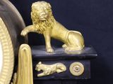 a black and gold clock with a lion on top of it