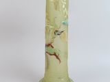 a green vase with a bird on it on a white background