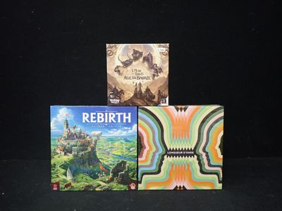 Trois livres sont posés sur une surface noire, sur fond noir.
