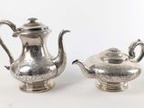 paire de théières anciennes en argent sur un support, sur fond blanc