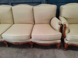 two couches and a chair in a room with a blue wall