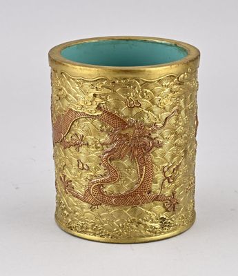 une coupe en or ornée d'un dragon sur un fond blanc