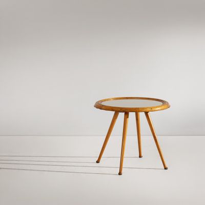 une petite table en bois avec un plateau en verre, posée sur un plan de travail blanc