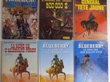 Six livres de la série « Blueberry Western » sont alignés sur une table