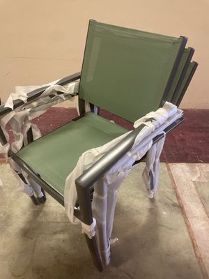 une chaise verte qui a été emballée et qui se trouve par terre