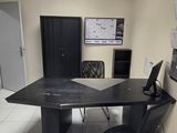 un bureau avec un ordinateur et une chaise dans une pièce