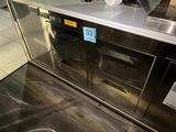 a stainless steel counter with two ovens and a coffee maker