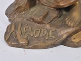 a bronze statue of a dog sitting on top of a rock