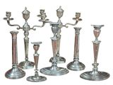 five silver candlesticks sitting next to each other on a white background