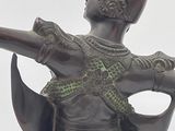 a bronze statue of a man holding a gun in his hand