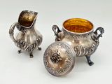 two silver vases sitting next to each other on a table