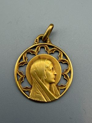 Gros plan sur une médaille d'or portant le visage d'une femme