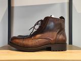 des bottes en cuir marron posées sur une étagère dans un magasin de chaussures