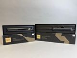 deux boîtes noires ornées d'un logo noir et doré