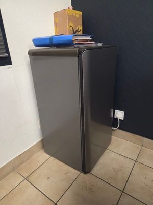 une photo d'un réfrigérateur dans une cuisine, avec une boîte posée dessus