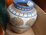 a blue and white vase in a box next to other vases