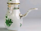 une cafetière blanche décorée de fleurs vertes
