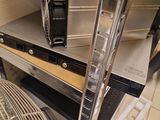 a microwave and a fan sitting on a shelf in a room