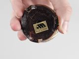 a person holding a piece of wood with a logo on it