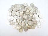 a pile of silver coins on a white surface