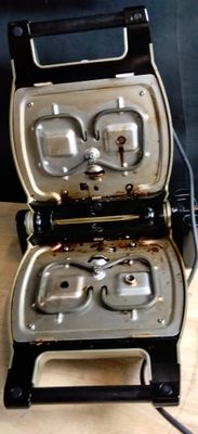 a toaster that is sitting on a table with two pans in it