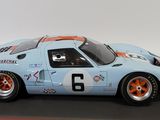the model of a blue and orange race car is on a black surface