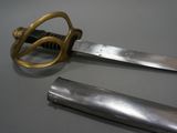 pair of two swords with a gold handle on a gray surface