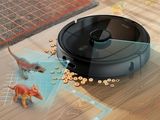 a robot that is sitting on the floor next to a toy dinosaur