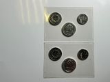four different types of coins on a white surface