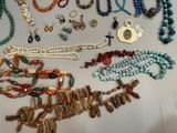 many different necklaces and bracelets laid out on a table