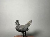 a bronze statue of a bird on a marble base