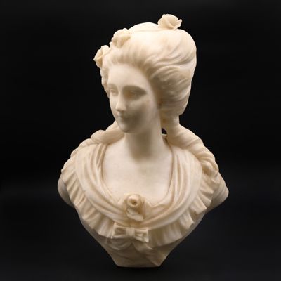 un buste en marbre blanc représentant une femme coiffée d'une couronne de fleurs