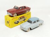 two toy cars sitting next to each other on a box