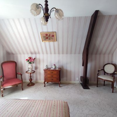 a room with a bed, chairs, and a chandelier in it
