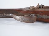 an old gun with a wooden handle on a white surface