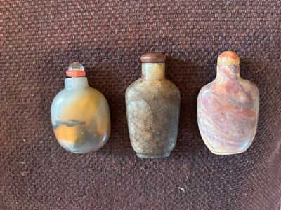 trois petits vases posés les uns à côté des autres sur une surface marron