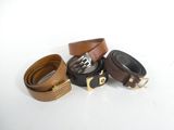 three belts with gold buckles on a white surface