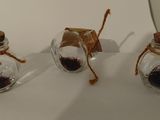 trois petits bocaux en verre remplis de grains de café posés sur une surface blanche