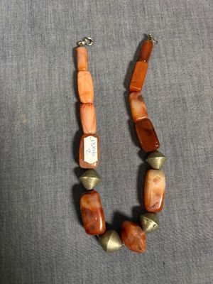 un gros plan d'un collier posé sur une surface grise