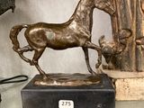 une statue de cheval posée sur une table en verre